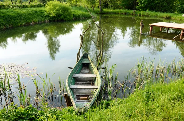 Eski ahşap tekne ayakta su birikintisi shore köprüde demirli — Stok fotoğraf