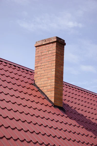 Brown tiled roof yellow brick chimney on sky — Stock Photo, Image