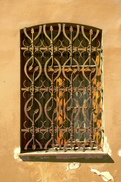 Окно старинного архитектурного дома со стальной решеткой — стоковое фото