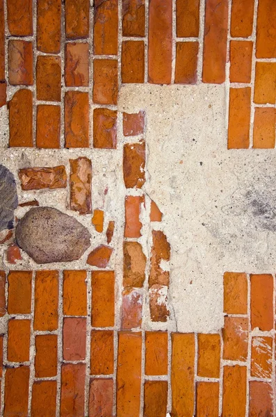 Frammento di antico muro di mattoni rossi con pietre formica cemento in esso . — Foto Stock