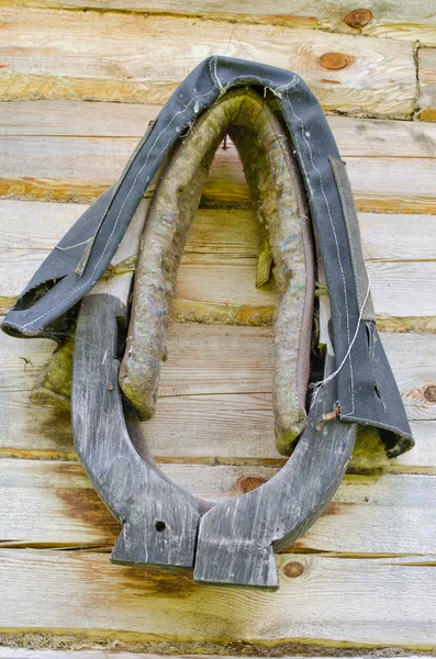 Horse harness hang on old homestead log house wall — Stock Photo, Image