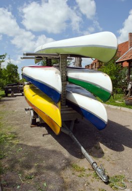 Kayaks canoes loaded on special transport trailer clipart