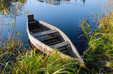 Retro wooden boat on lake shore. water transport clipart