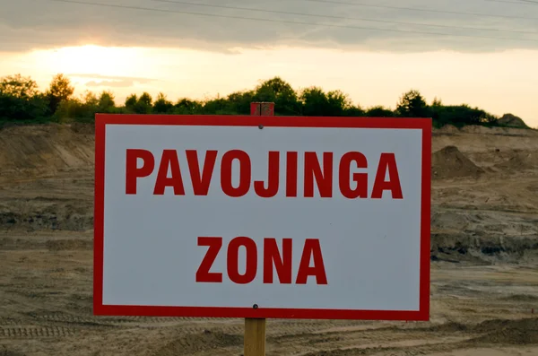 Sinal de aviso lituano Zona de perigo em canteiro de obras e pôr do sol — Fotografia de Stock