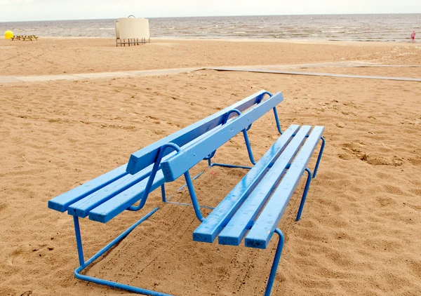 Blue bench and bathing-box on seaside beach sand — Stock Photo, Image