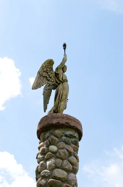 Angel hold torch on stone platform sky background — Stock Photo, Image