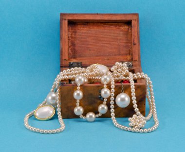 Pearl jewelry in retro wooden box on blue clipart