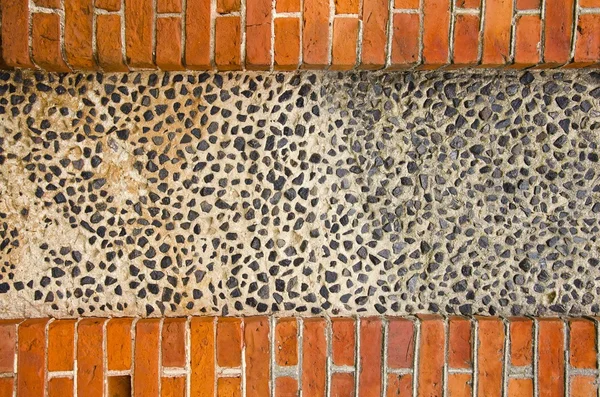 Vägg av tegel och betong med lite stenar — Stockfoto