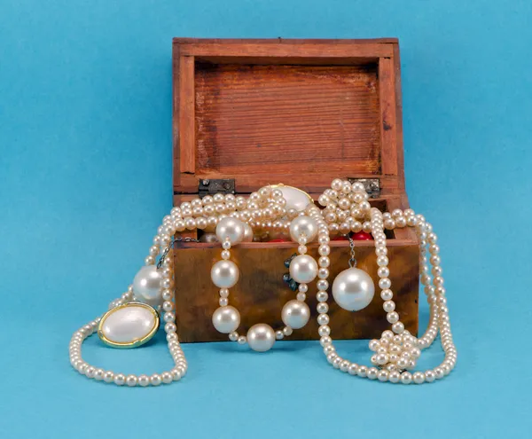 Жемчужные украшения в ретро деревянной коробке на синий — стоковое фото
