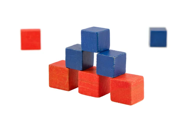 Pirâmide feita de tijolos de brinquedo de cor azul vermelho de madeira — Fotografia de Stock