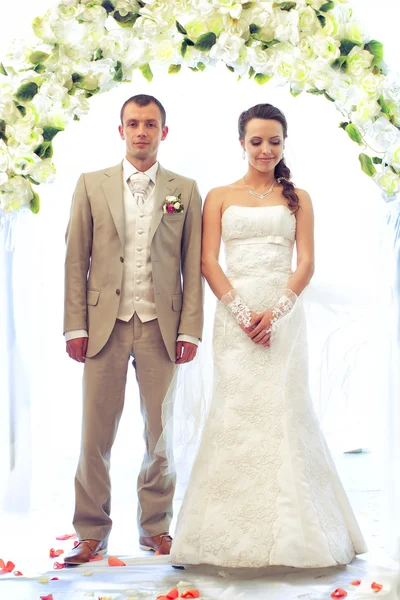 Bruden och brudgummen poserar på vit — Stockfoto