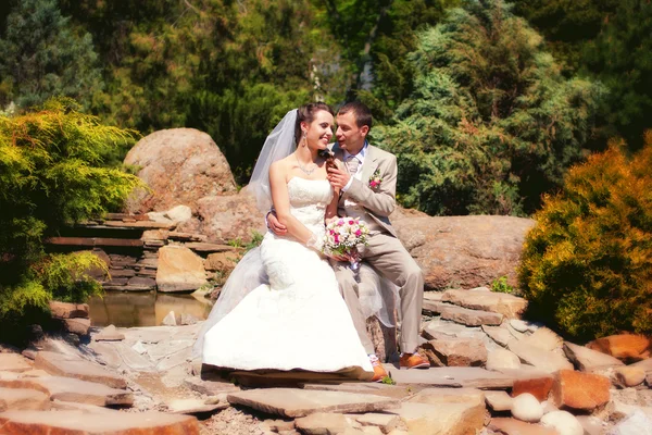 Nevěsta a ženich pózuje v parku — Stock fotografie