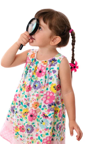 Malá holčička, dívat se skrz zvětšovací sklo — Stock fotografie