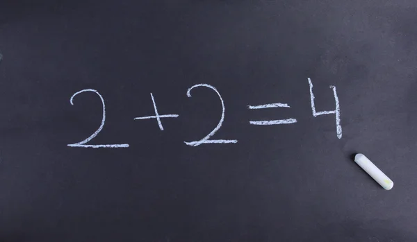 A young student has solved a basic math equation on a chalkboard. — Stock Photo, Image