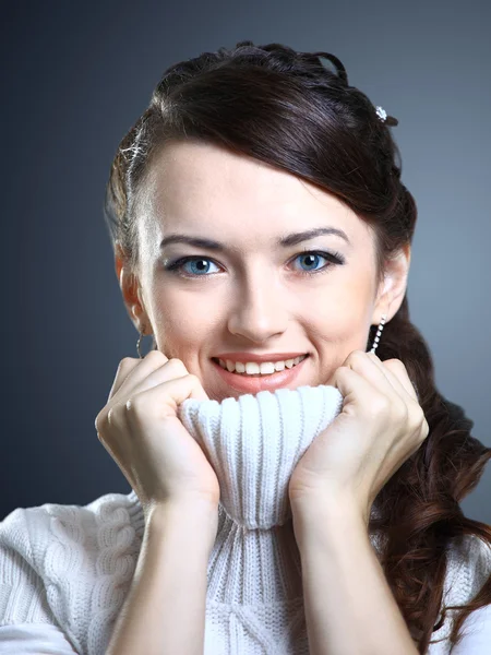 Όμορφο κορίτσι χαμόγελα σε ένα πουλόβερ. απομονωμένη σε ένα γκρίζο φόντο. — Φωτογραφία Αρχείου