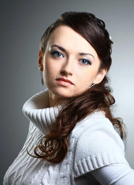 Hermosa chica en suéter. Aislado sobre un fondo gris . — Foto de Stock