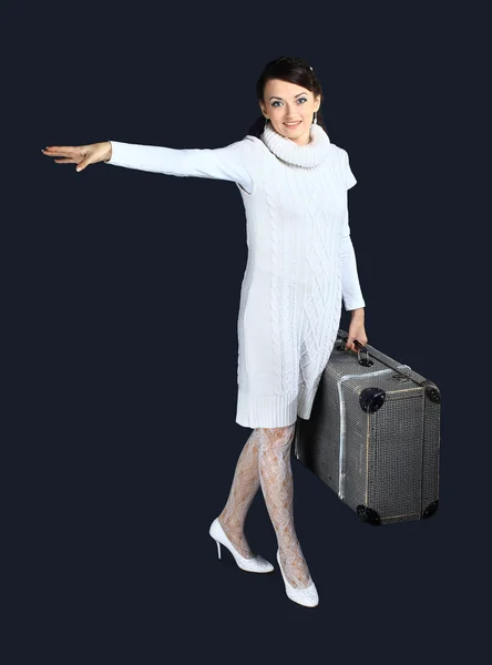 Όμορφο κορίτσι στα λευκά, με μια μεγάλη βαλίτσα. απομονωμένη σε ένα μαύρο φόντο. — Φωτογραφία Αρχείου