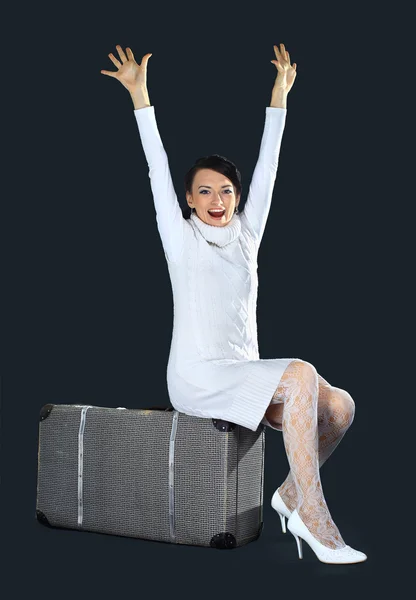 Hermosa chica en blanco, con una maleta grande. Aislado sobre un fondo negro . — Foto de Stock
