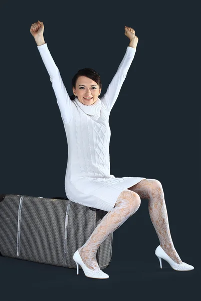 Vacker flicka i vitt, med en stor resväska. isolerad på en svart bakgrund. — Stockfoto