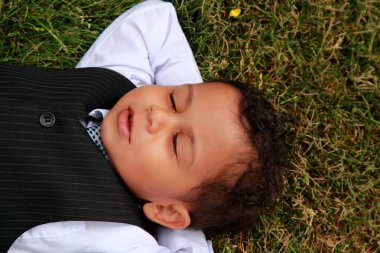 Young boy lying on grass