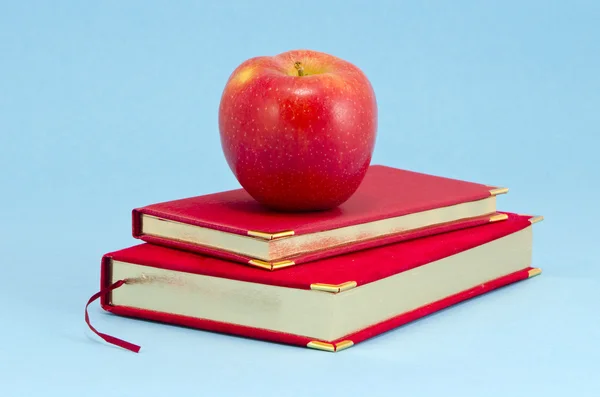 Złocone biznesu dziennik i czerwone jabłko — Zdjęcie stockowe