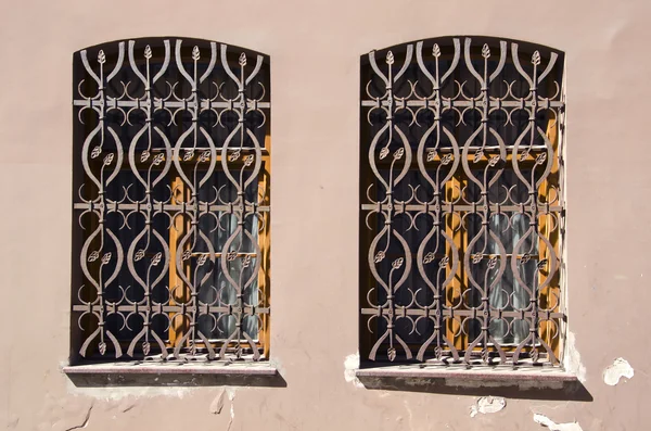 Deux vieilles fenêtres avec des grilles métalliques — Photo