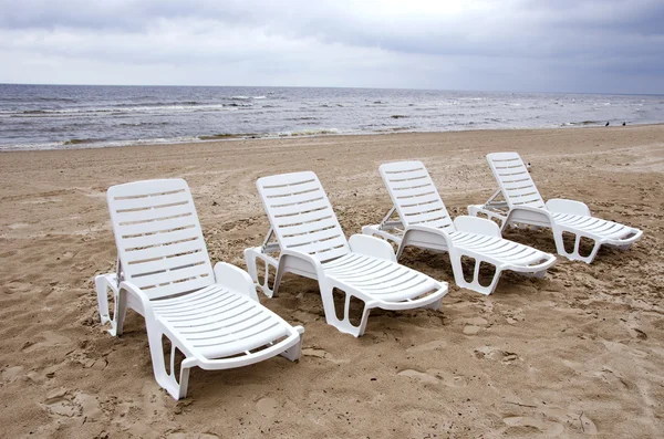 Sedie bianche vuote vicino al mare sulla sabbia della spiaggia — Foto Stock