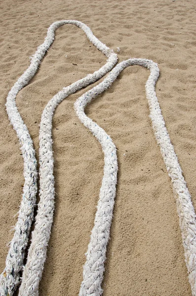 Cuerdas de barcos viejos en arena de playa de mar — Foto de Stock