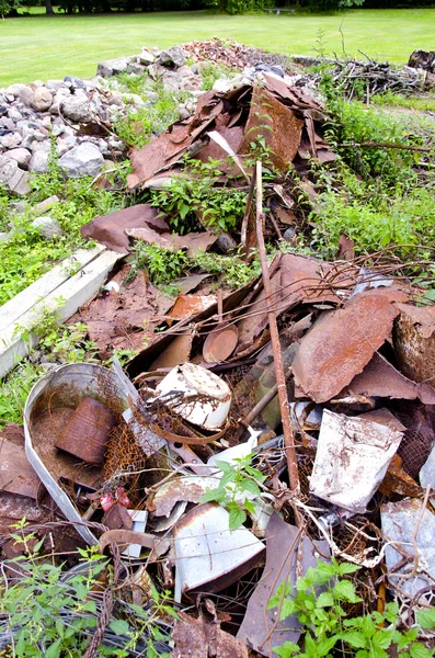 Desechos de hierro oxidado en la hierba de la granja —  Fotos de Stock