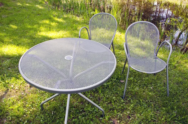 Современный металлический стол и стул в парке — стоковое фото