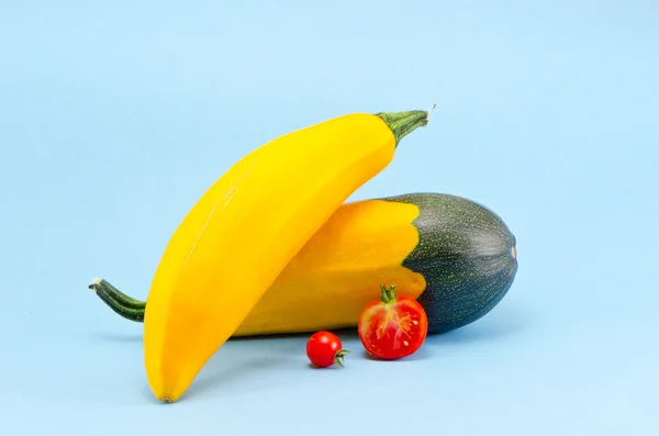 Gul zucchini och röd tomat på azurblå bakgrund — Stockfoto