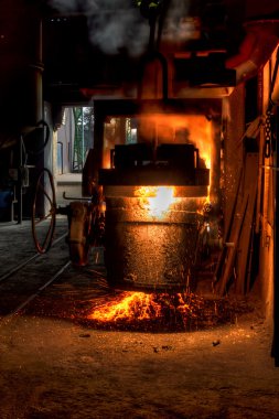 Ladle of molten steel in a iron foundry clipart