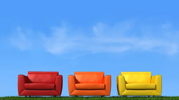Три кресла на траве — стоковое фото