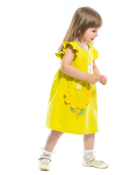 एक पिवळा ड्रेस मध्ये एक सुंदर लहान मुलगी स्टॉक इमेज