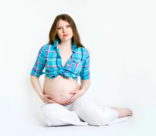 Beautiful pregnant woman in a plaid shirt — Stock Photo, Image