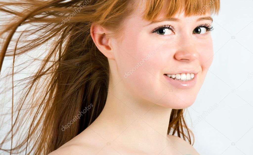 Beautiful young red-haired woman with long beauty straight hair.