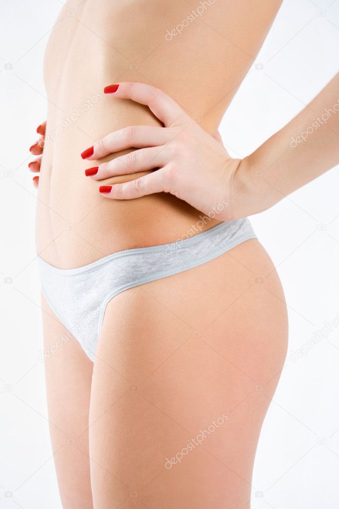 Slim tanned woman's body isolated over gray background. Healthy