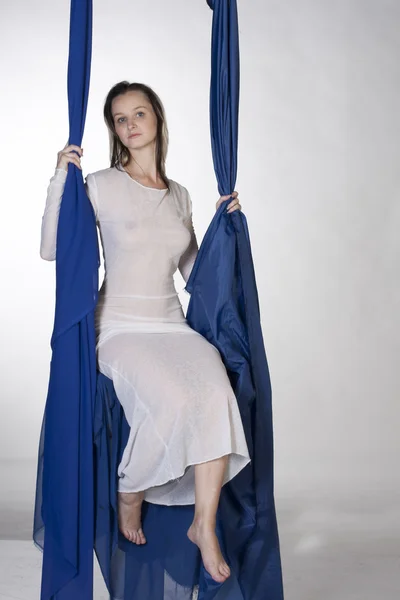 Bir salıncak üzerinde oturan uzun elbiseli bir kız — Stok fotoğraf