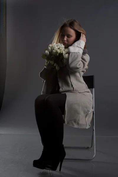 Porträt eines schönen Mädchens in Winterkleidung mit einem Blumenstrauß — Stockfoto