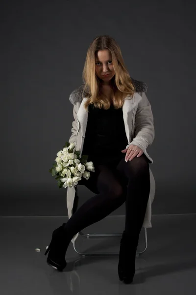 Retrato de una hermosa chica en ropa de invierno con un ramo de flores —  Fotos de Stock