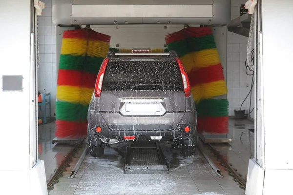 El coche en un lavado automático de coches . Fotos De Stock