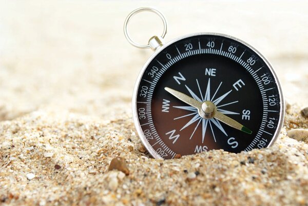 компас на морском песке и место для текста
