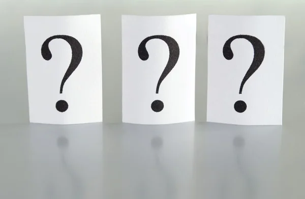 Big question mark on a piece of paper on a gray background — Stock Photo, Image