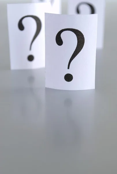 Grande punto interrogativo su un pezzo di carta su sfondo grigio — Foto Stock