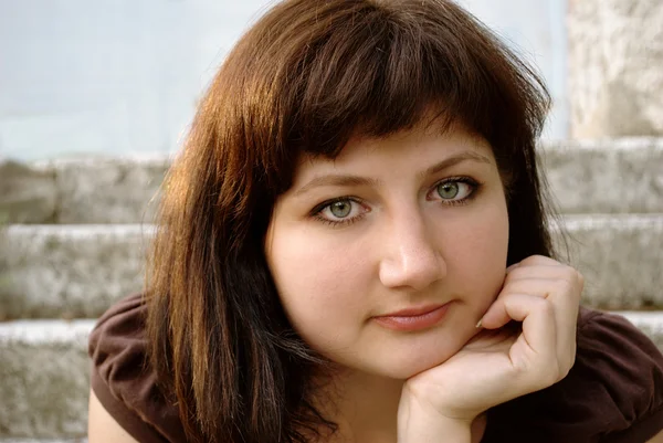 stock image Young girl with brown hair on the background of the building