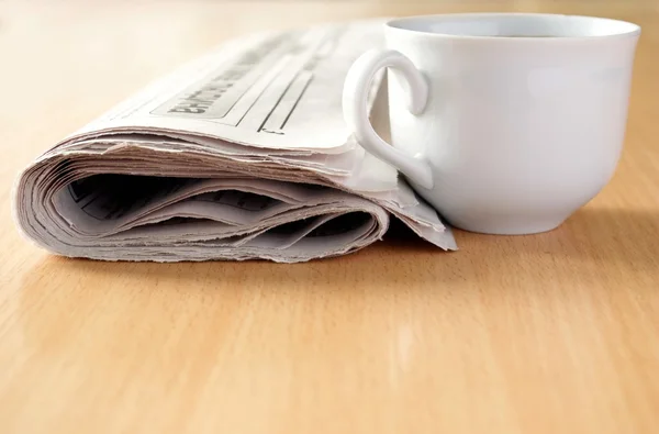 Filiżankę kawy i gazety na stole — Zdjęcie stockowe