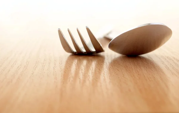 Vidlička a lžíce na dřevěný stůl — Stock fotografie