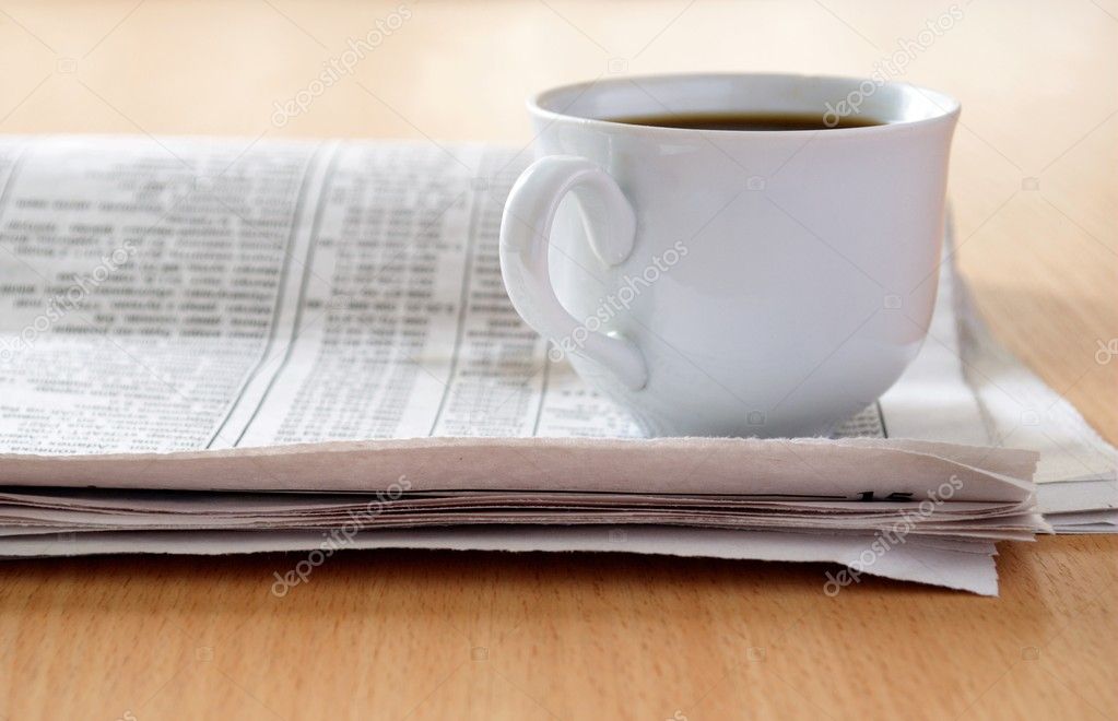 Cup of coffee and the newspaper on the table
