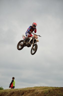 Motocross rider in flight removes the protective film from the g clipart