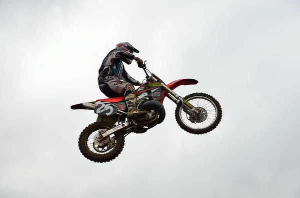 Мотогонщик на мотокроссе летит высоко — стоковое фото